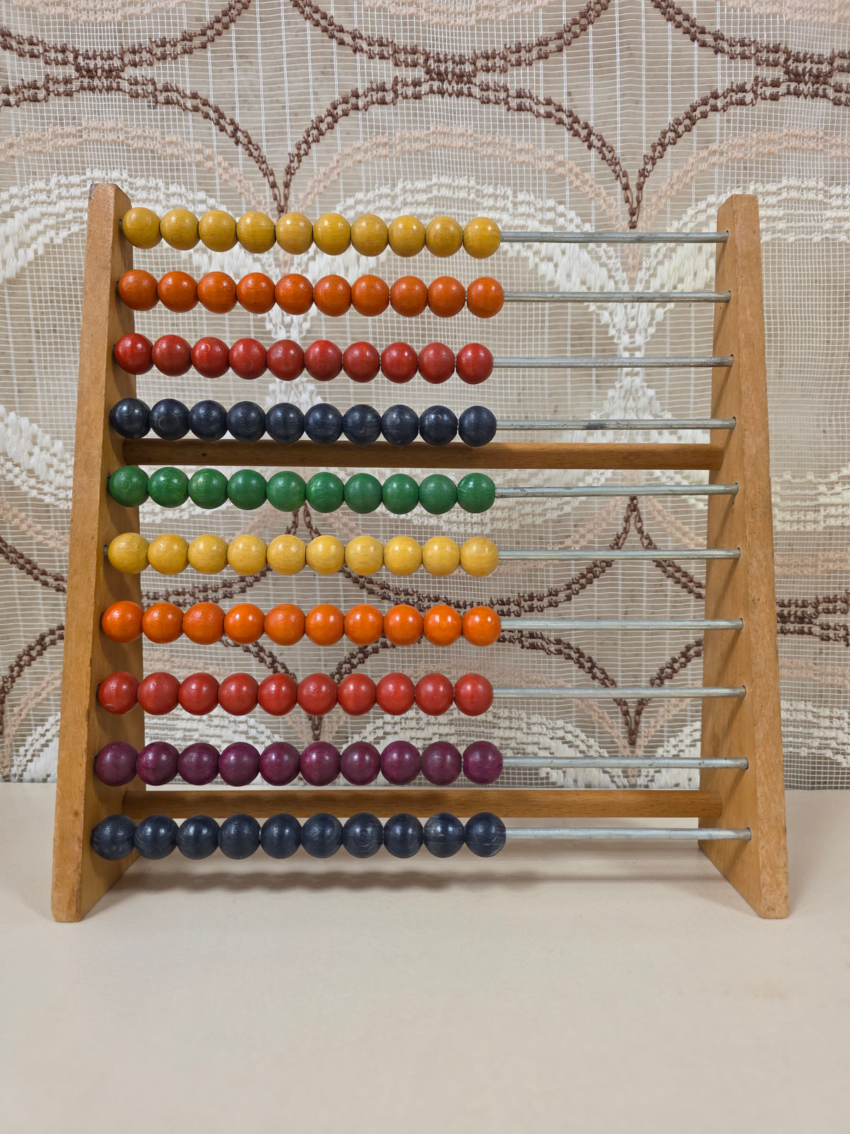 Vintage SIO houten telraam met gekleurde kralen in geel, oranje, rood, groen en blauw