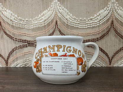 Witte keramische recept soepkom met recept voor champignonsoep en illustraties van champignons.