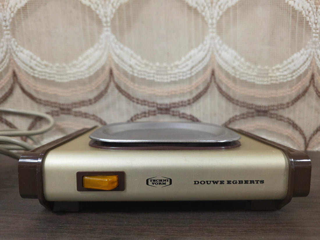 Technivorm warmhoudplaat voor Douwe Egberts in goudkleur met bruine accenten.