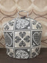 Vintage theebeurs met knip in grijs-witte stof met sierlijk patroon voor een theepot.