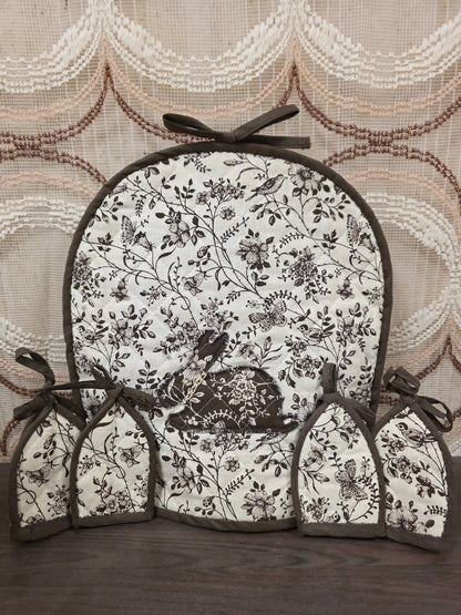 Theemuts met vier eierwarmers in bruin witte bloemenprint met konijnmotief