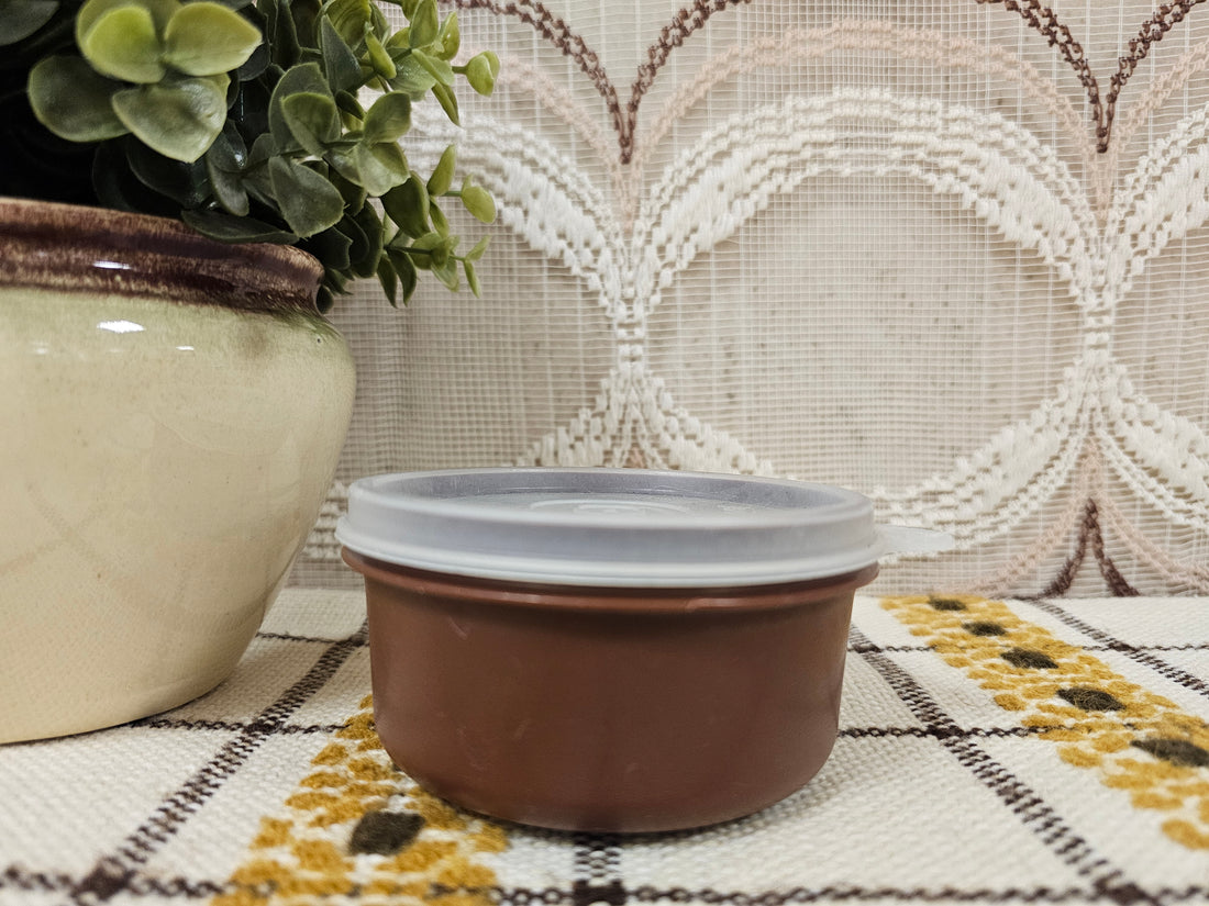 Rond vintage Tupperware bakje met bruine deksel, diameter 9,5 cm, hoogte 5 cm.