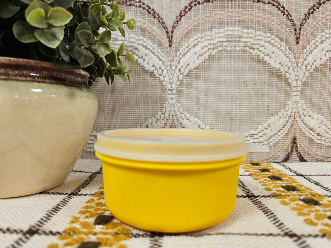 Rond vintage Tupperware bakje in geel met stevige deksel, diameter 9,5 cm, hoogte 5 cm.