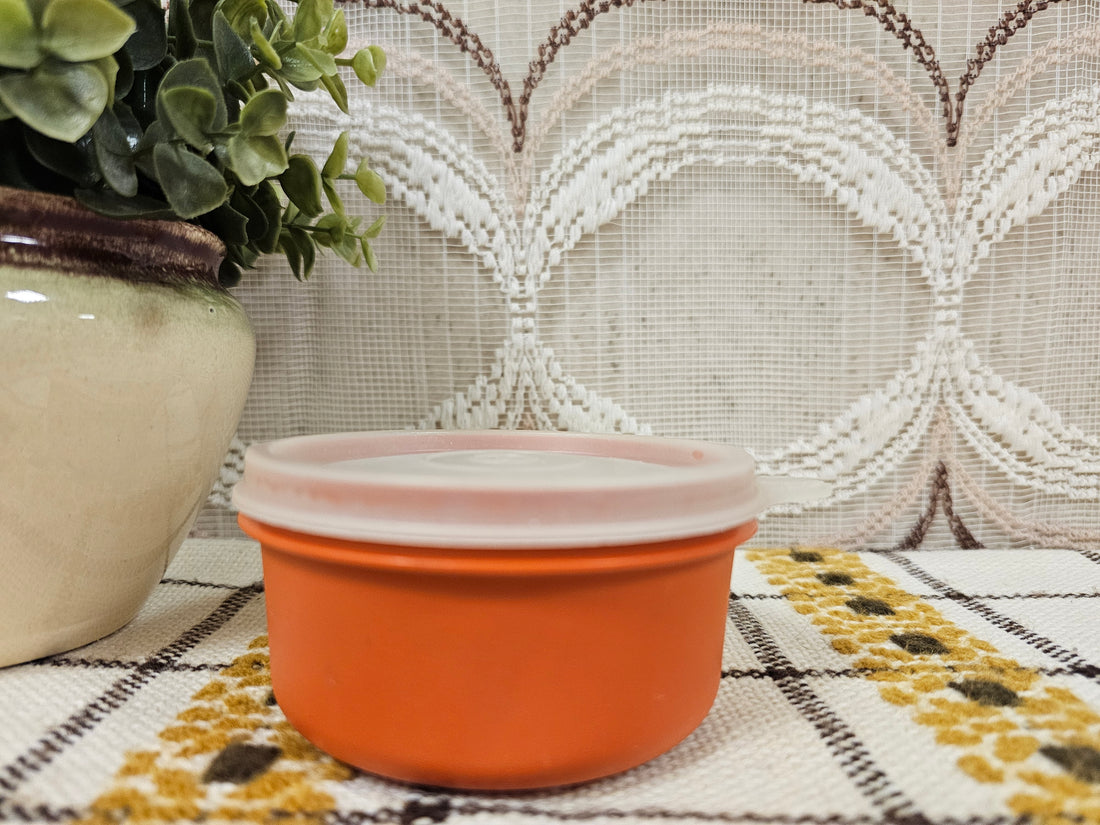 Rond vintage Tupperware bakje in roestoranje met stevige deksel, diameter 9,5 cm, hoogte 5 cm.