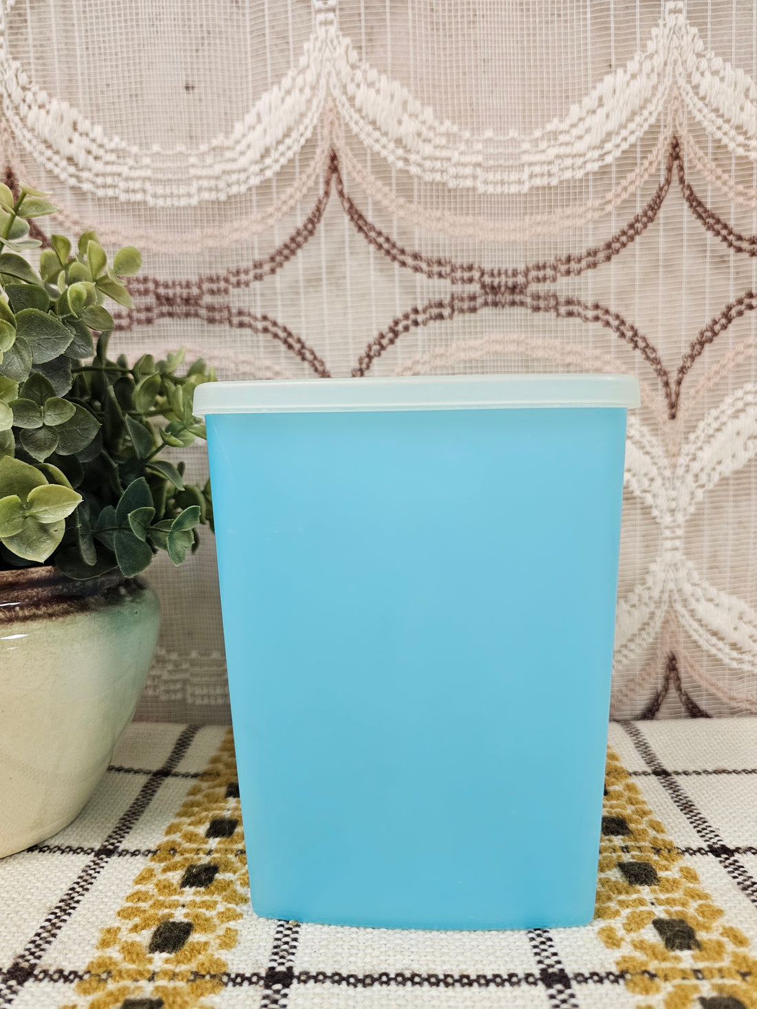 Vintage Tupperware voorraadbus in pastelblauw met deksel, 16 cm hoog.