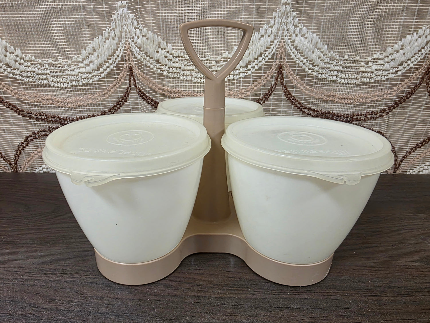 Vintage Tupperware Trio met drie crèmekleurige bewaarbakjes en lichtbeige draagrek