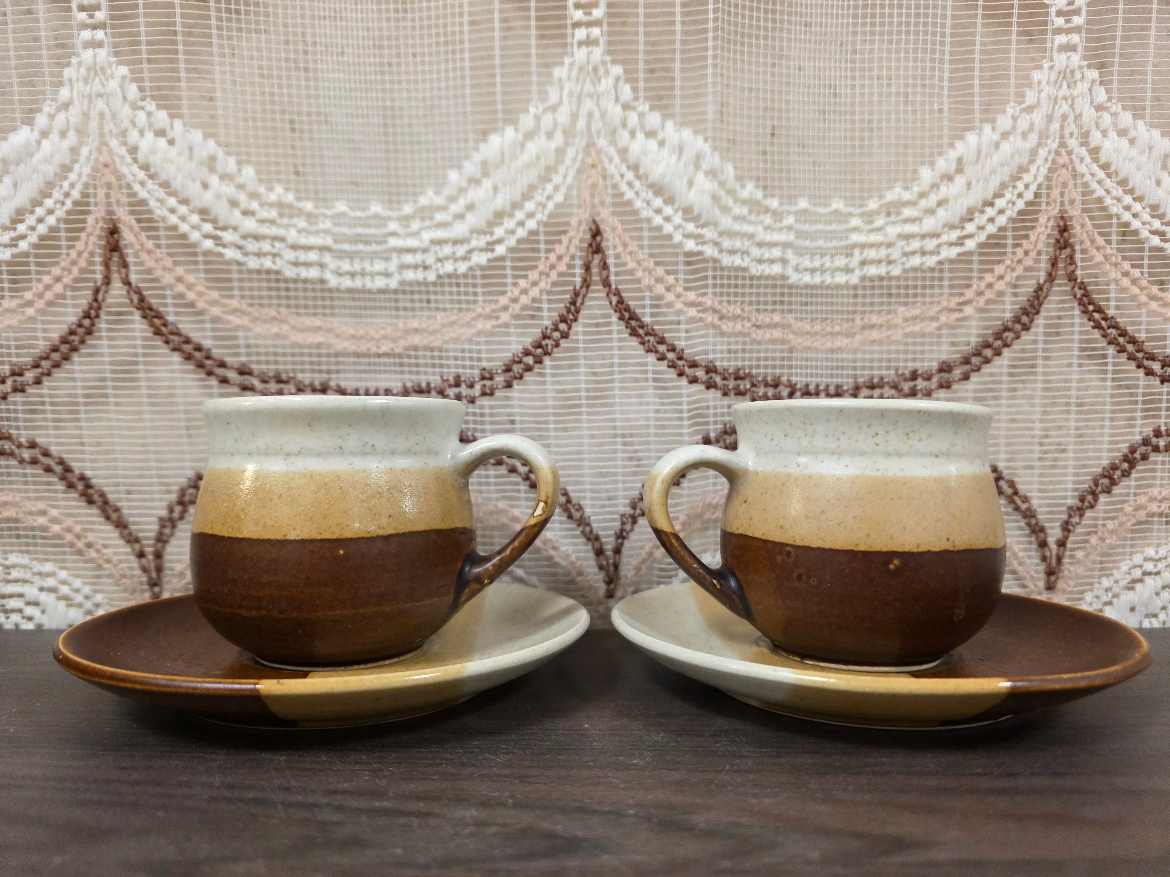 Set van twee kop en schotel aardewerk in bruin en crème, 7 cm hoog