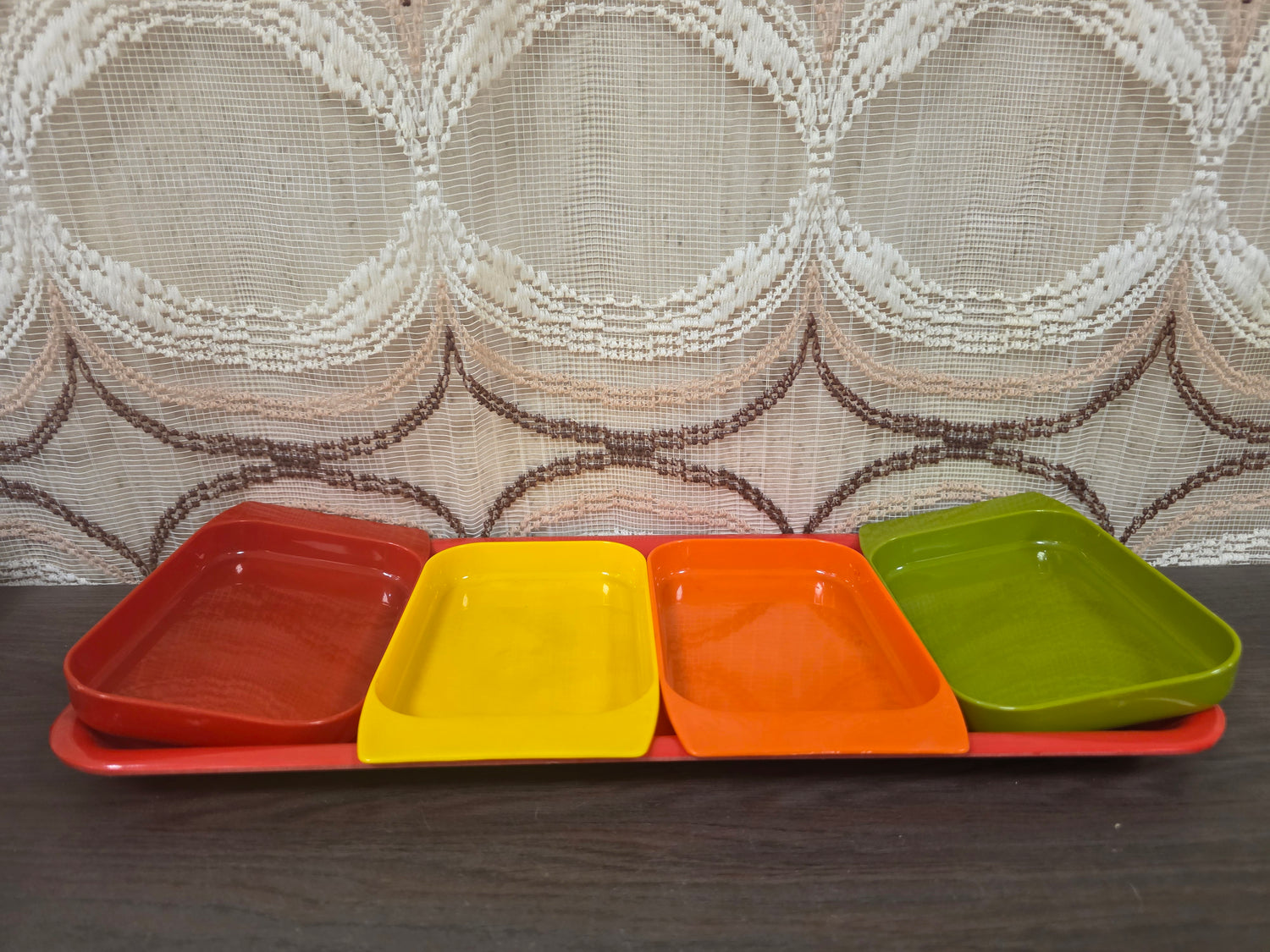 Vintage kunststof serveerschaal met vier losse snackschaaltjes in rood, oranje, geel en groen.