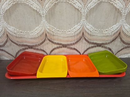 Vintage kunststof serveerschaal met vier losse snackschaaltjes in rood, oranje, geel en groen.
