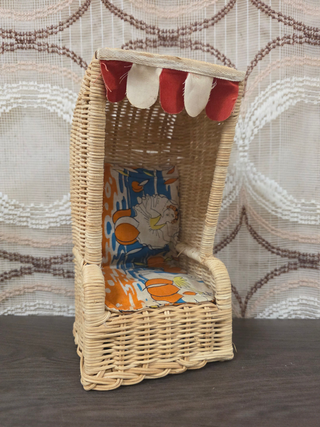 Vintage rotan strandstoel voor Barbie met rood-witte luifel en beklede zitting.