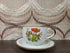Vintage Wildflower kop en schotel van lichtgekleurd keramiek met subtiele spikkels, bruine rand en een decor van rode en paarse bloemen met kleine veldbloemen.
