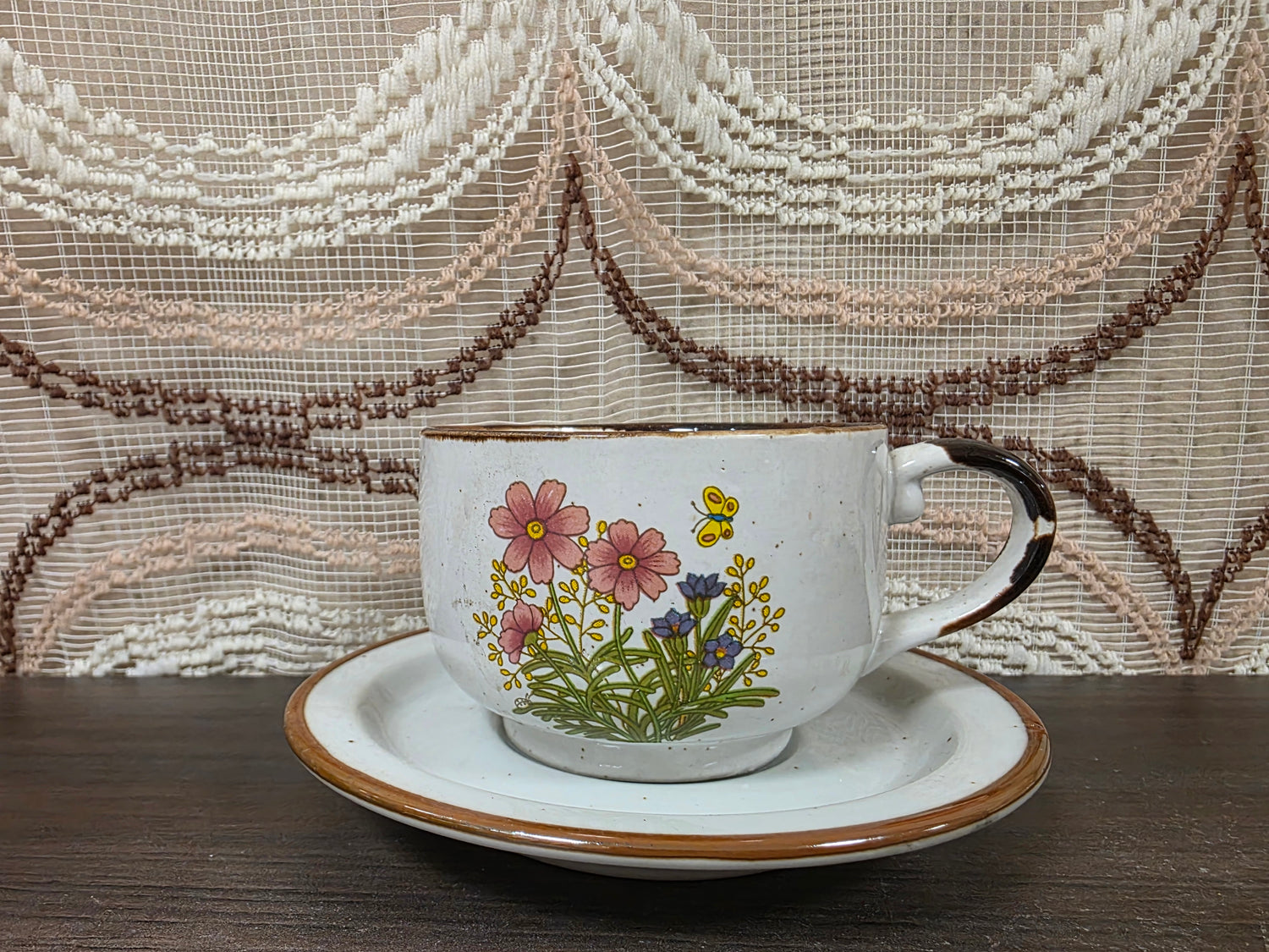 Vintage Wildflower kop en schotel van lichtgekleurd keramiek met subtiele spikkels, bruine rand en een decor van roze bloemen met kleine veldbloeme