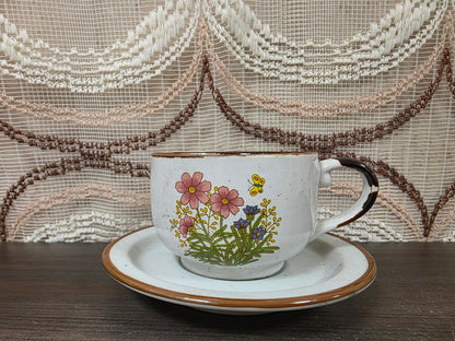 Vintage Wildflower kop en schotel van lichtgekleurd keramiek met subtiele spikkels, bruine rand en een decor van roze bloemen met kleine veldbloeme
