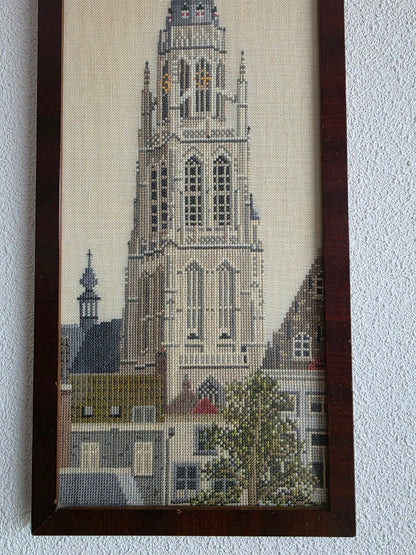 Detail van het borduurwerk met de toren, huizen en boom