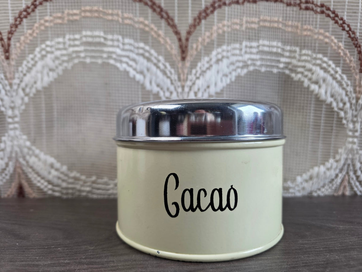 Vintage crème Brabantia cacaoblik met zwarte letters en zilverkleurig deksel