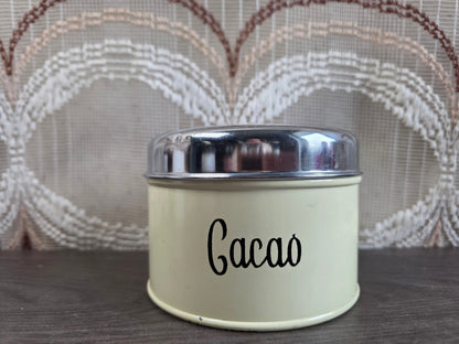 Vintage crème Brabantia cacaoblik met zwarte letters en zilverkleurig deksel