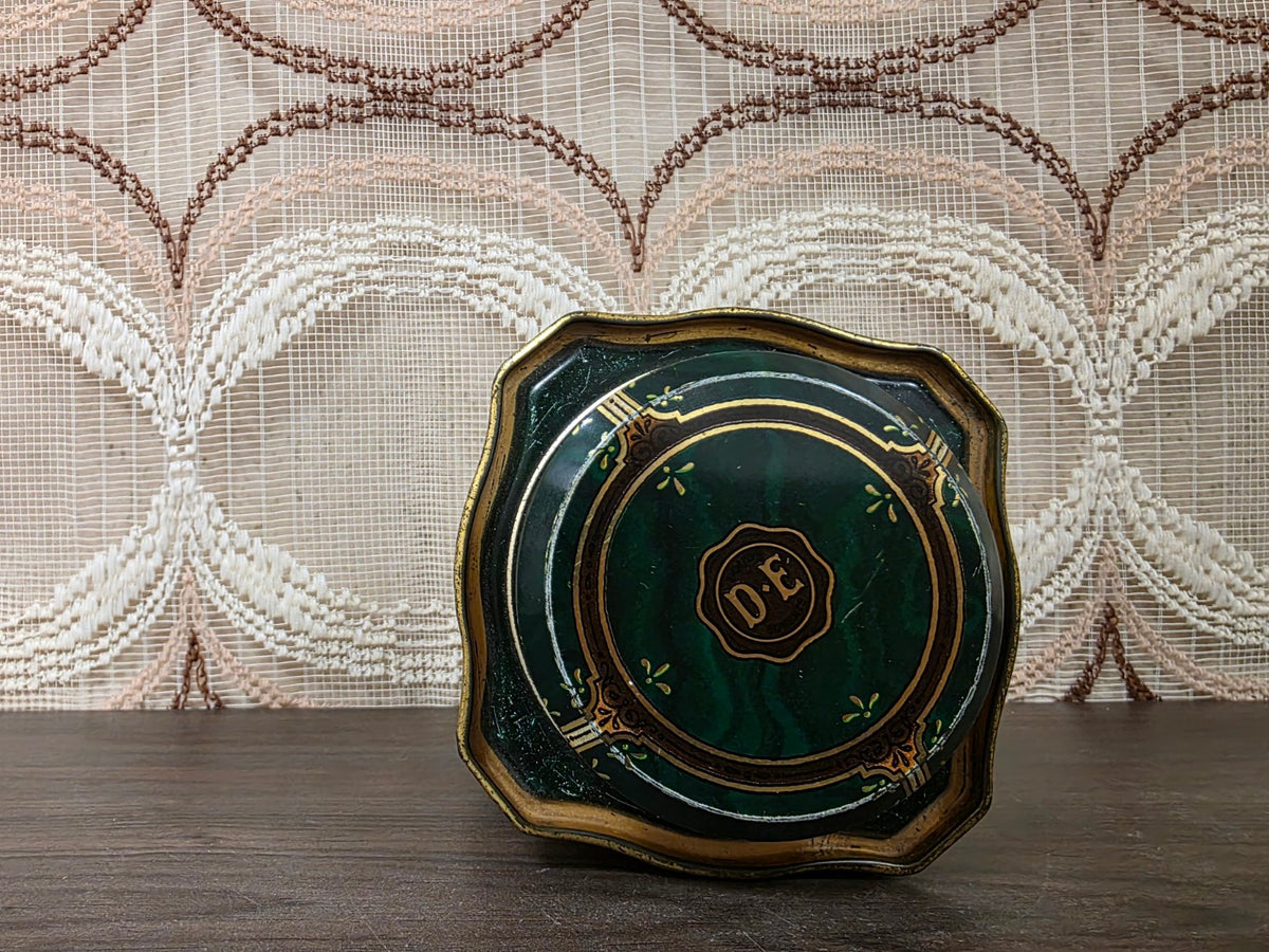 Bovenzijde van groen Pickwick theeblik met D E monogram op het deksel