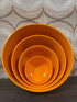 Vintage Fixit melamine schalenset met vier oranje schalen.
