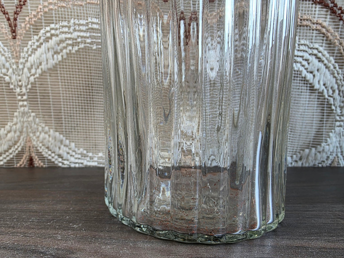 Detail van het geribbelde glas en de geschulpte onderrand
