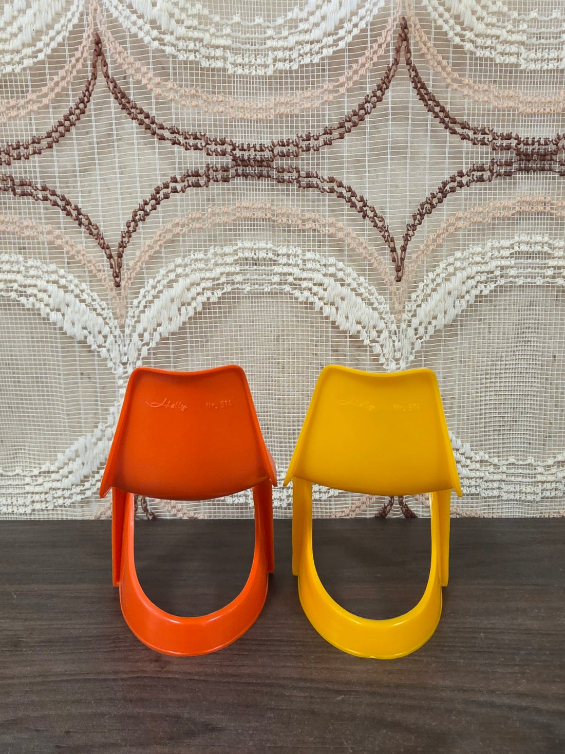 Achterzijde van twee Helly Nr. 514 poppenstoelen in oranje en geel