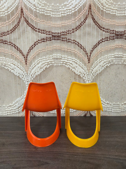 Achterzijde van twee Helly Nr. 514 poppenstoelen in oranje en geel