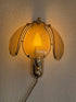 Hollywood Regency wandlamp met rookglazen panelen en boommotief, brandend aan de muur
