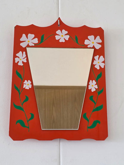 Oranje wandspiegel met witte bloemen en groene bladeren, vooraanzicht