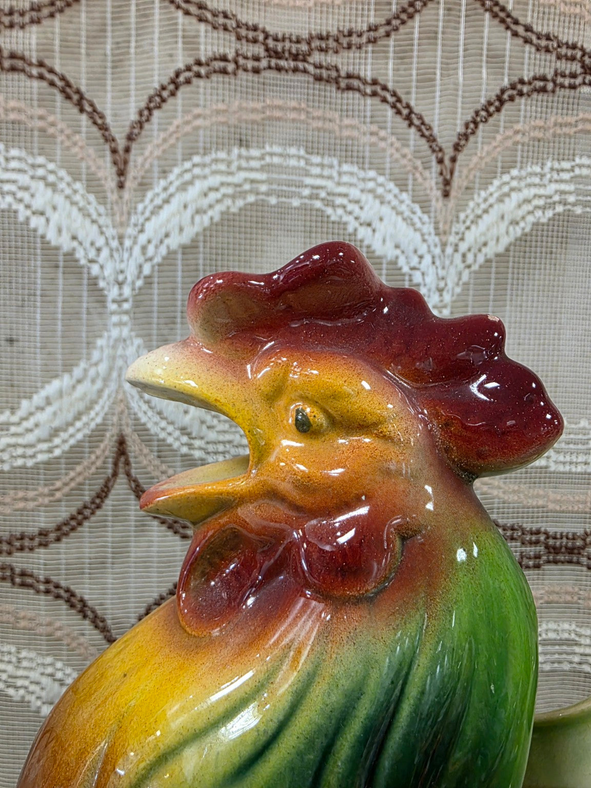 Close-up van de hanenkop met rode kam, gele snavel en groene hals van de Saint-Clément schenkkan