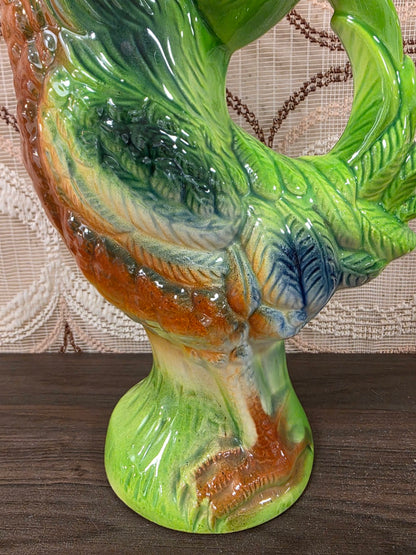 Detail van het gekleurde verenkleed en de voet van de keramische Saint-Clément haan