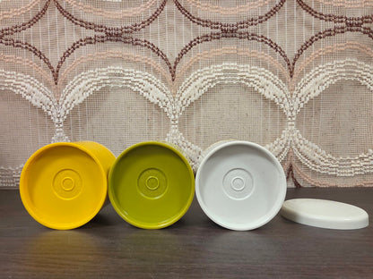 Onderkanten van drie Tupperware kruidenstrooiers met merkstempels