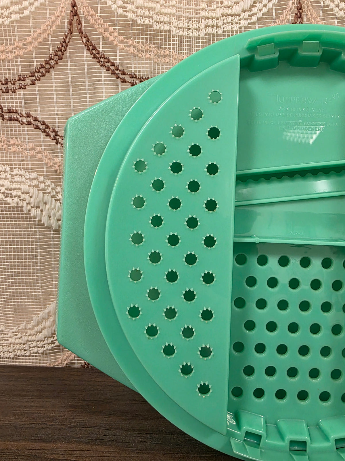 Detail van het linker raspvlak met gekartelde gaatjes van de mintgroene Tupperware rasp