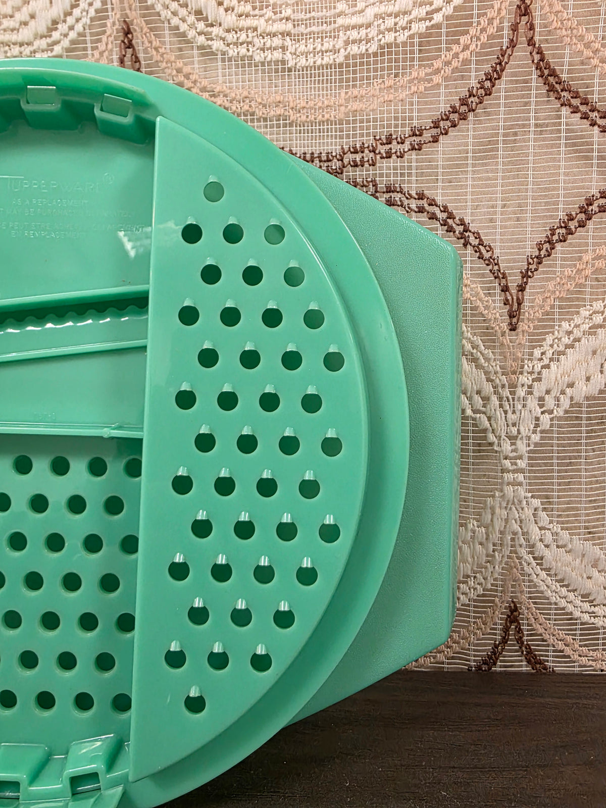 Detail van het rechter raspvlak met ronde openingen van de mintgroene Tupperware rasp