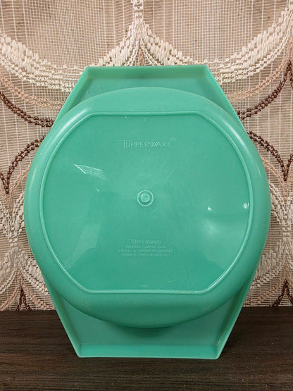 Onderzijde van de mintgroene Tupperware opvangkom met merknaam en zichtbare krasjes