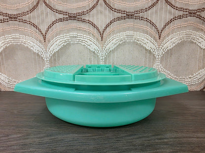 Zijaanzicht van de mintgroene Tupperware rasp op de opvangkom met brede handgrepen