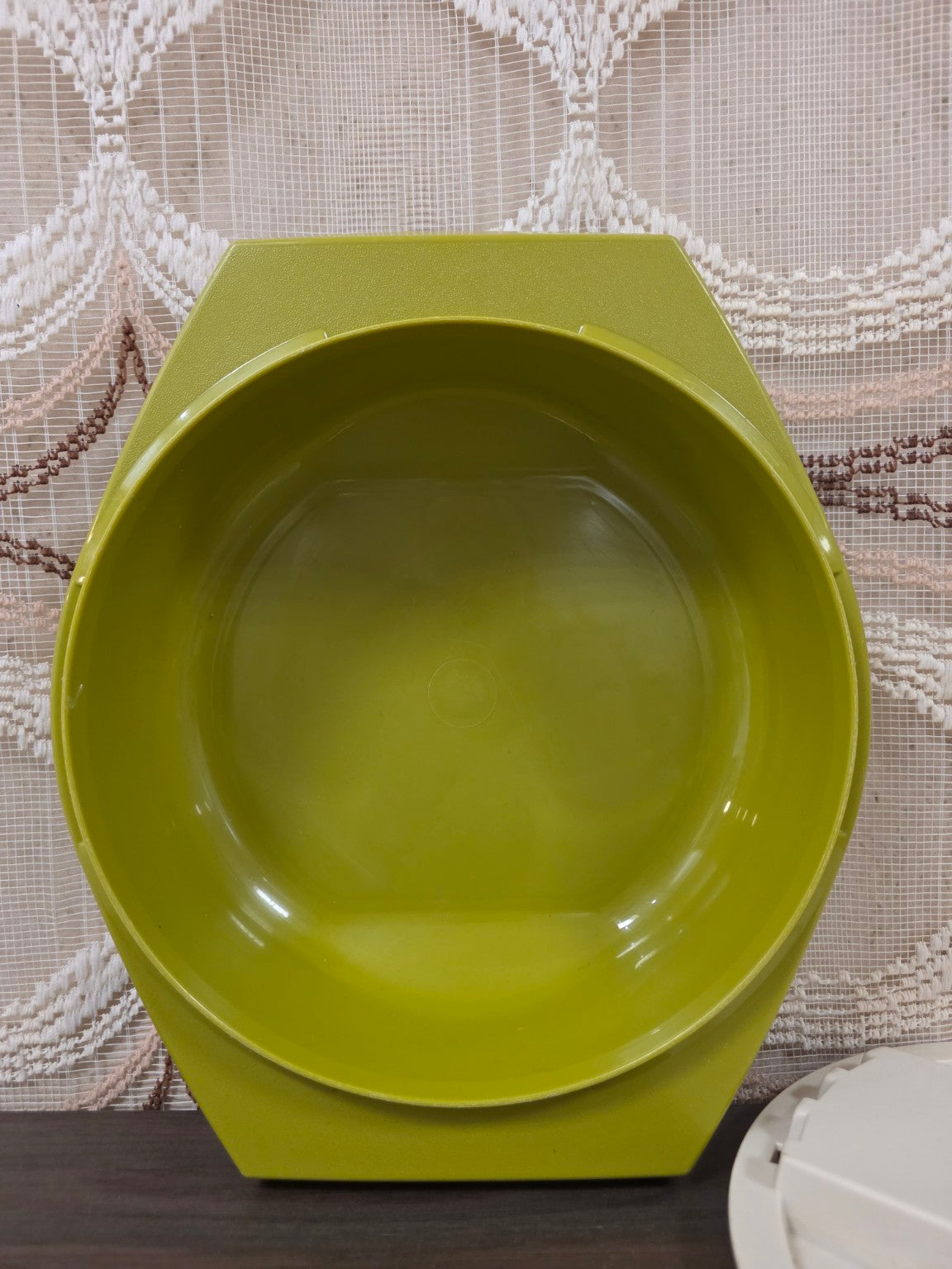 Binnenzijde van de olijfgroene Tupperware opvangkom met zichtbare krasjes