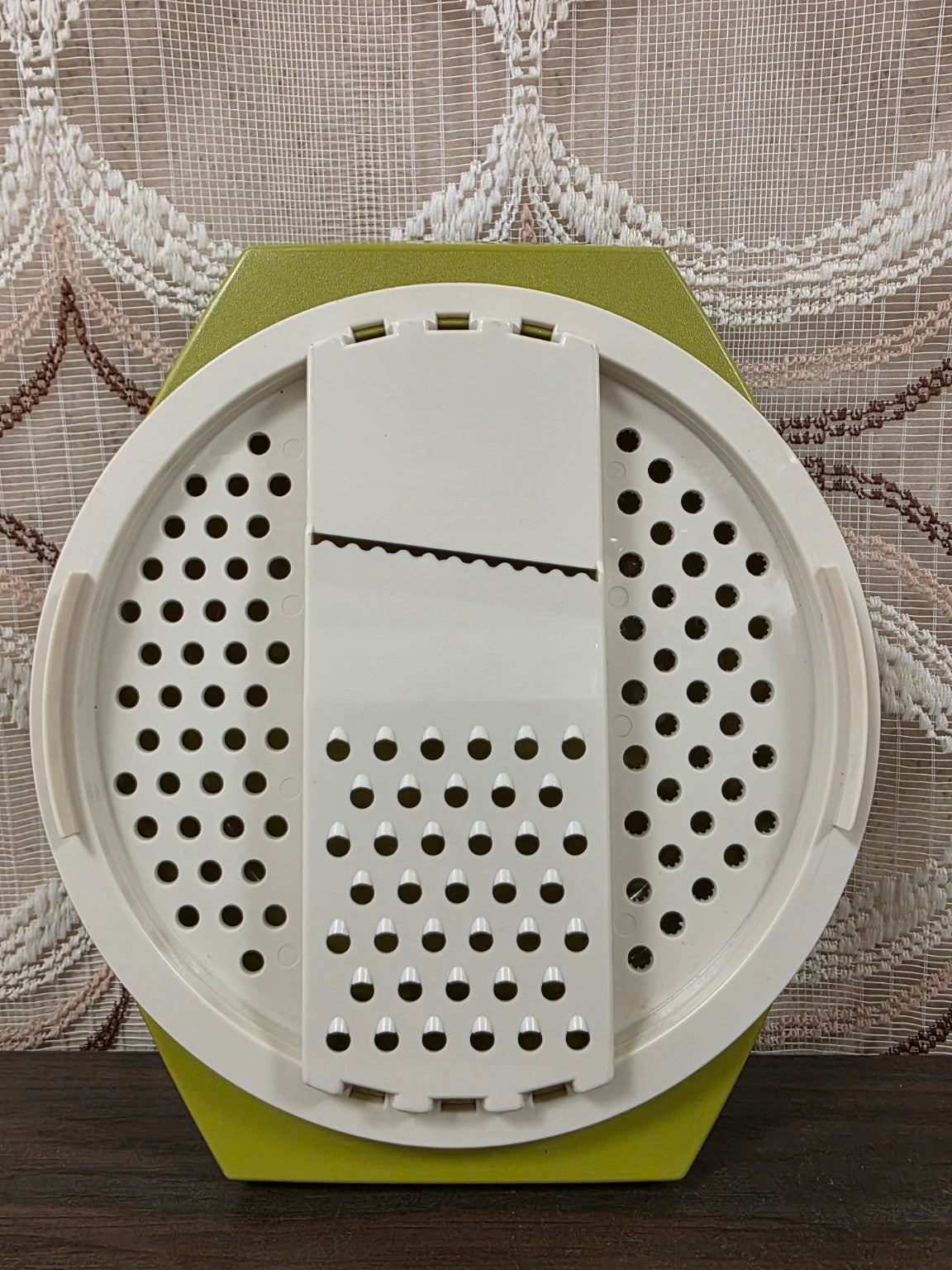 Olijfgroene Tupperware rasp met witte raspinzet, van bovenaf