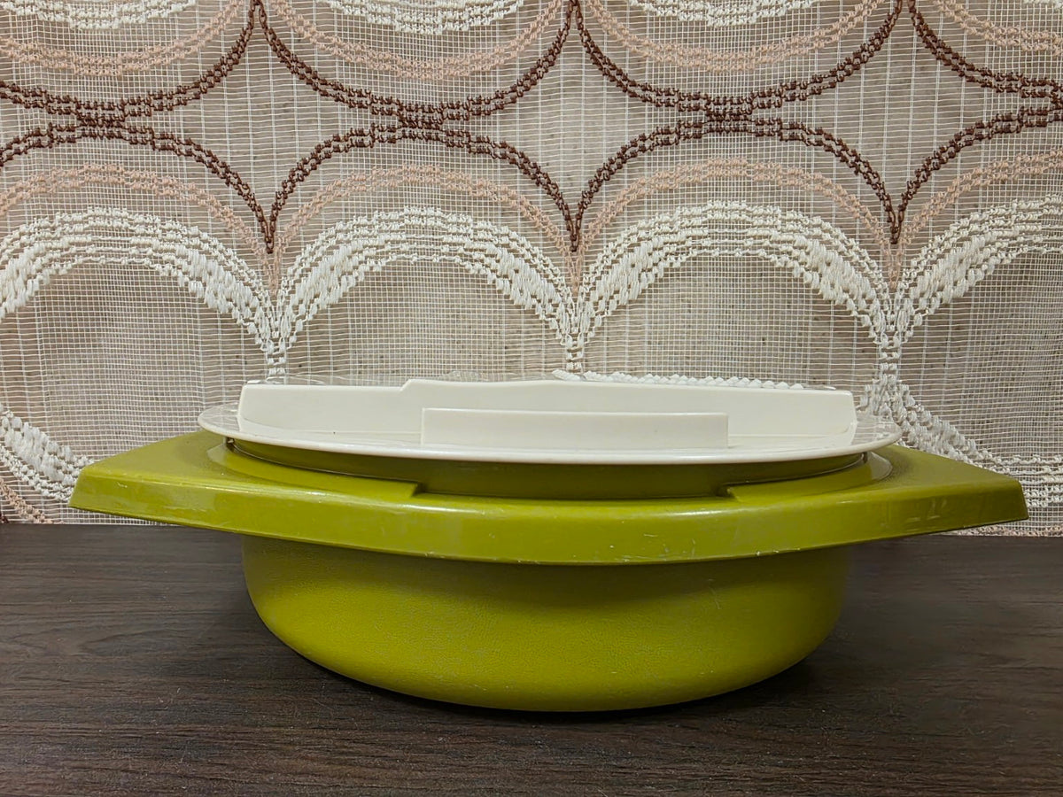 Olijfgroene Tupperware opvangkom met witte raspinzet, van opzij