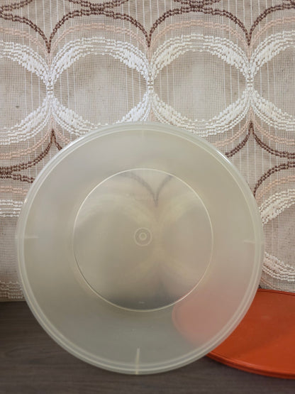 Binnenkant van de ronde Tupperware voorraadbus met het oranje deksel ernaast