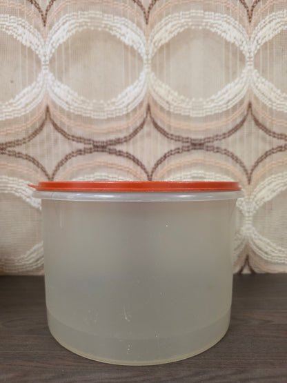Vooraanzicht van de grote halftransparante Tupperware trommel met oranje deksel