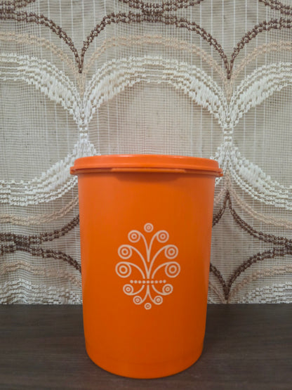 Vintage oranje Tupperware voorraadbus met wit decor en originele sterdeksel. 15.5 cm hoog