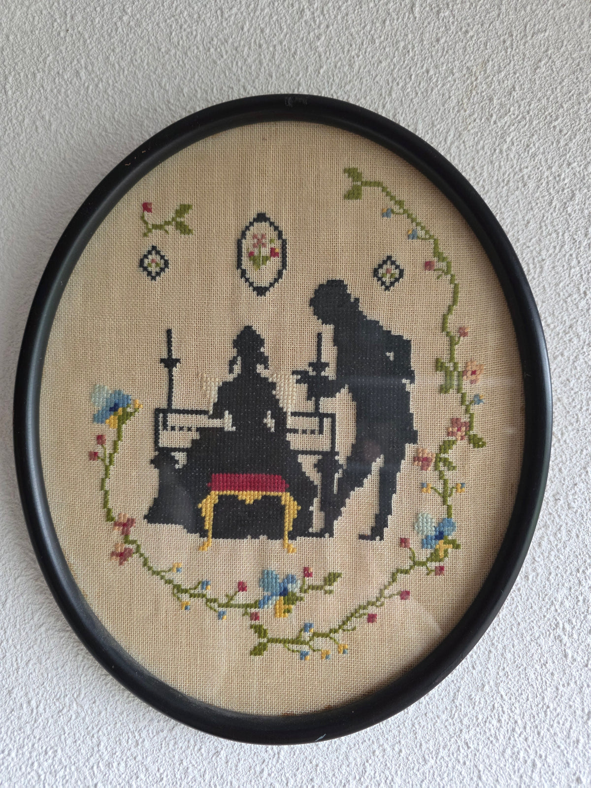 Vintage borduurwerk ovaal stel bij piano lijst