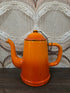 Vintage oranje emaille koffiepot met deksel aan kettinkje.