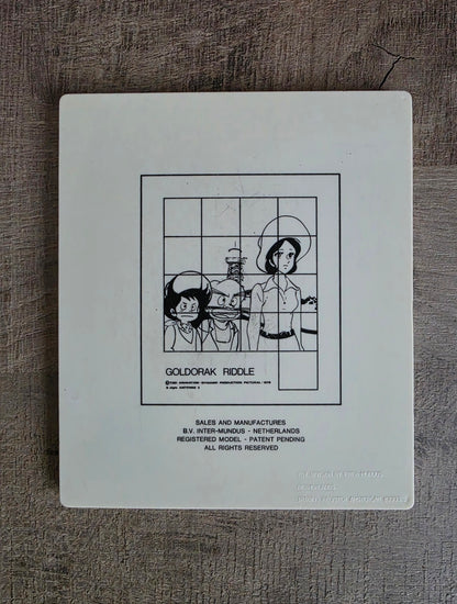 Achterkant Goldorak Riddle schuifpuzzel met voorbeeldafbeelding en vermelding B.V. Inter-Mundus Netherlands