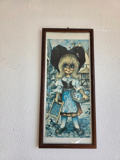 Vintage ingelijste prent van blond meisje met grote blauwe ogen en zwarte strik in donkerbruine houten lijst
