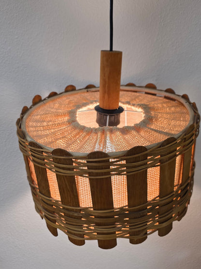 Vintage rotan hanglamp met houten latjes, brandend