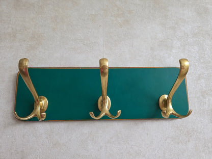 Vintage wandkapstok petrolgroen met drie sierlijke messingkleurige dubbele haken