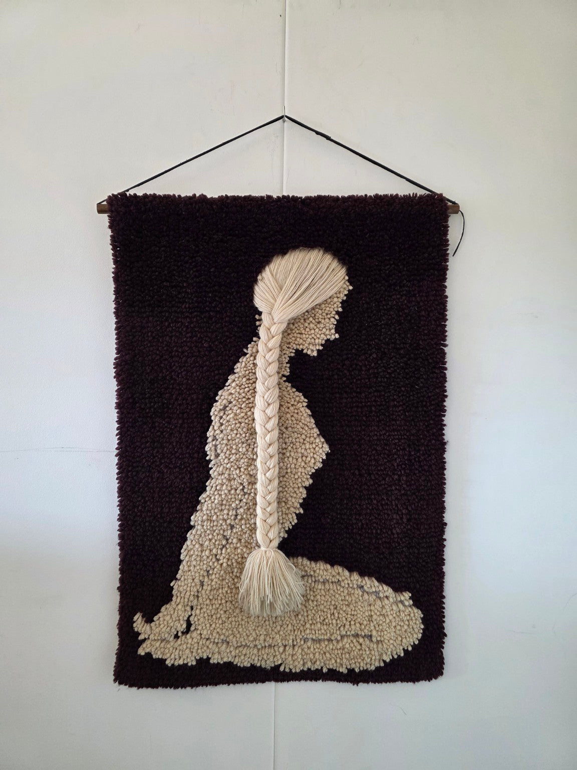 Vintage wandkleed met crèmekleurige zittende vrouw en lange losse vlecht op donkerpaarse achtergrond