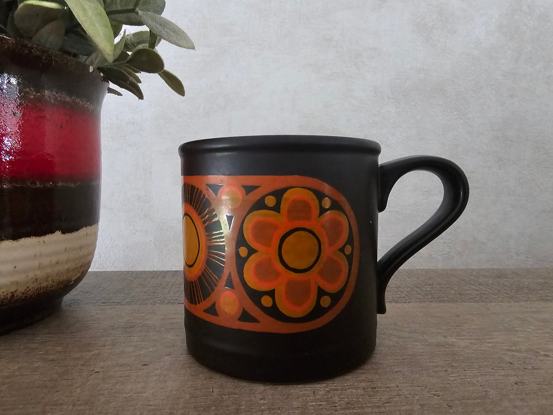 Donkerbruine koffie beker oranje bloemen