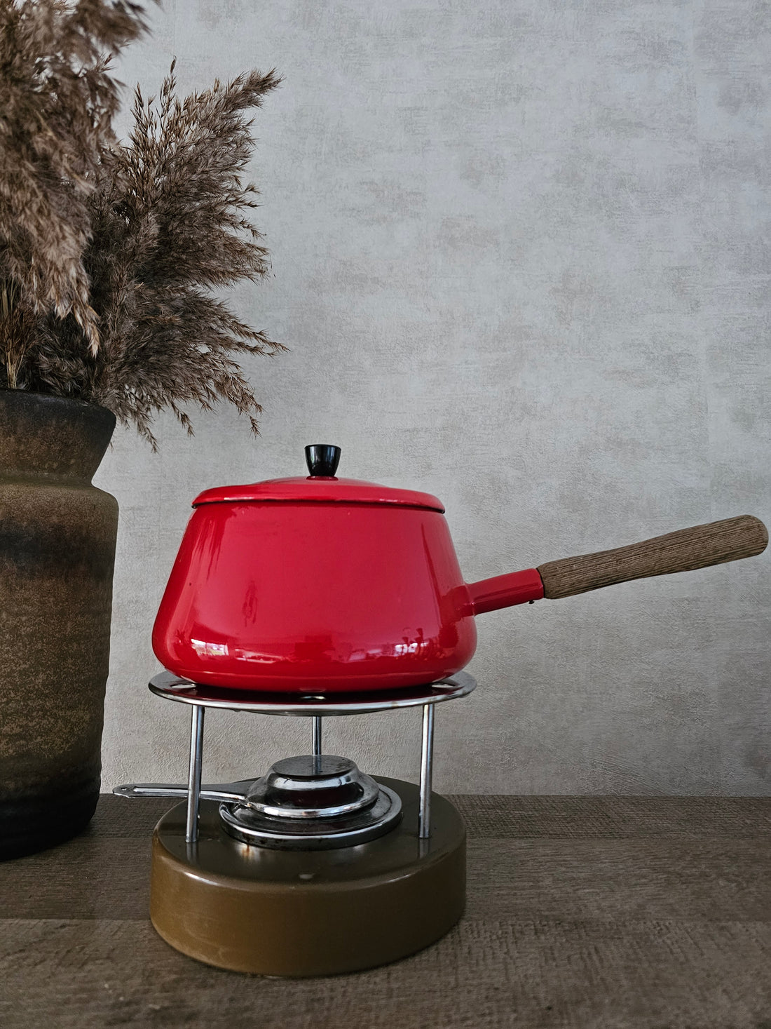 vintage rode fonduepan met brander op bruin onderstel