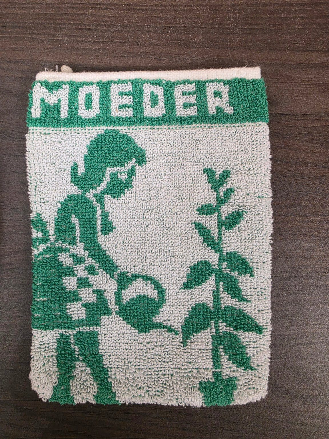 Detail van groen-wit washandje met opschrift MOEDER en afbeelding van vrouw met bloemen
